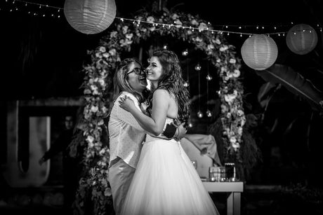 Two brides smiling under the alter.