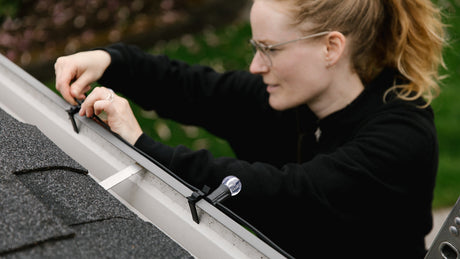 Black Multi Clips Installer clipping them into roofline