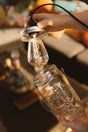 Mason Jar pendant lantern glowing outdoors